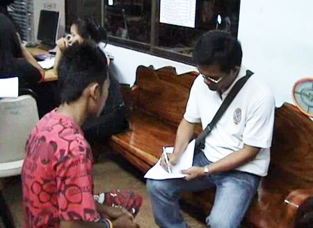 Thanakorn Putaka, left, gives a statement to Pattaya police.